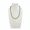 Beaded stretch necklace on mannequin with light green and dark round stones, gold spacers