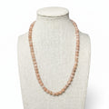 Peach-toned gemstone beaded stretch necklace on a mannequin, round beads
