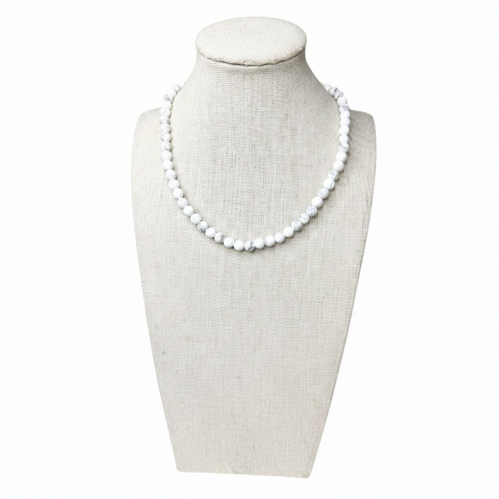 Matte white howlite beaded stretch necklace on display bust, small round beads