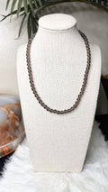 Smoky quartz bead necklace with dark gray-brown round stones, displayed on bust