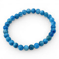 Blue apatite beaded stretch bracelet with glossy round blue beads on white background